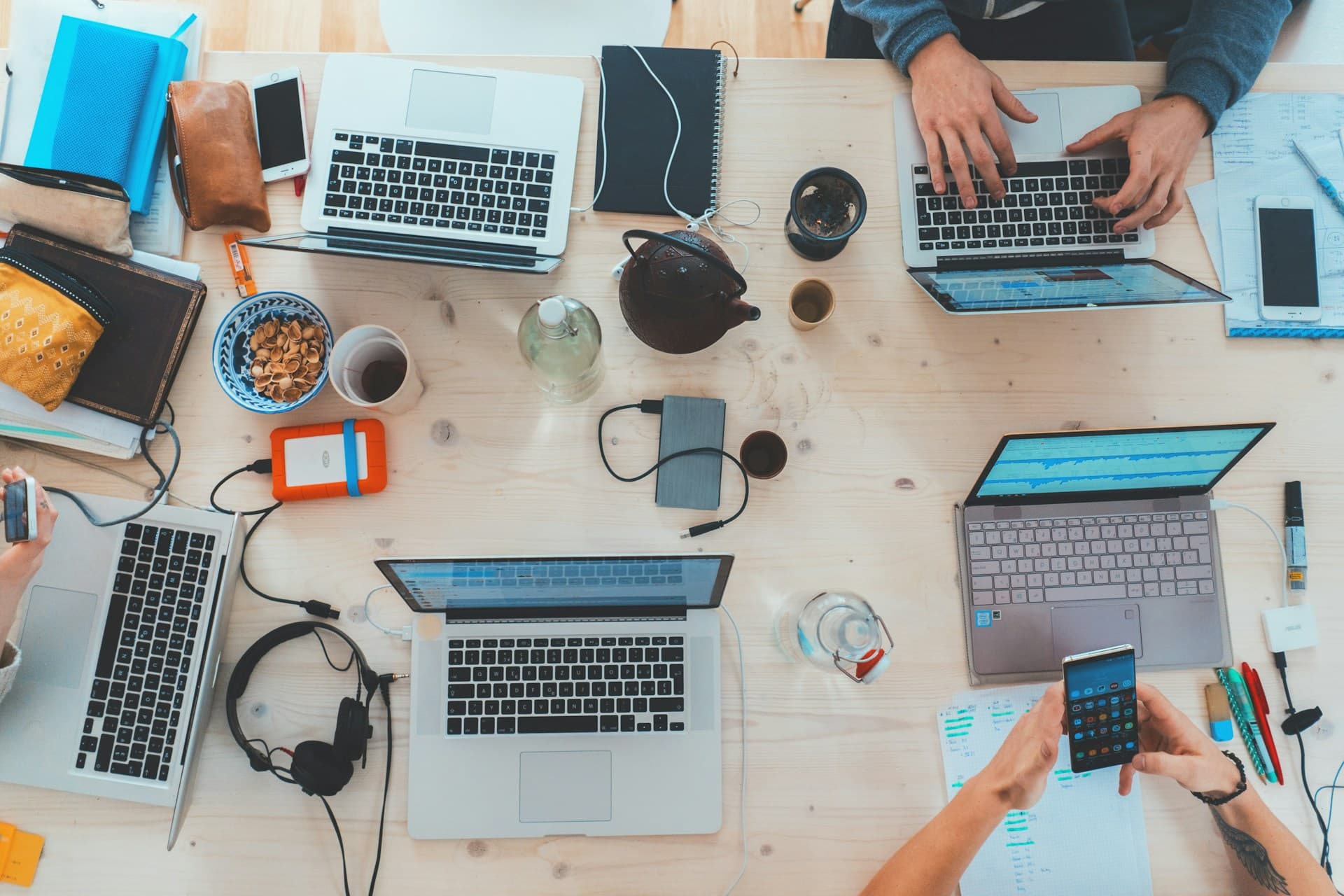 A team buried in laptops, spreadsheets, and manual prospecting